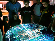 Various forms of Interactive Digital Tables have been being made by Onomy Labs for a number of years now (the first was introduced and demonstrated in 1999).  Unlike Microsoft Surface and other touch-based screen displays, the Tilty Table actually articulaes to provide an intuitive and physical interface to the projected content.  Accelerometers keep track of the table's angle.  Variants of the table include the Twisty Table (where Torque is instrumented) and the Spinny Table (where rotation of the tabletop is instrumented).  Tilting the table caused the projected content to flow off the low side of the surface.  Spin and Torque are used to zoom an image in and out for more detail...sometimes literally (like with map data), sometimes figuratively (like with a more abstract data representation).